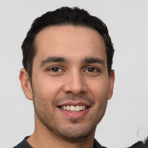 Joyful white young-adult male with short  black hair and brown eyes