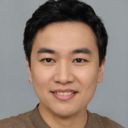 Joyful asian young-adult male with short  brown hair and brown eyes