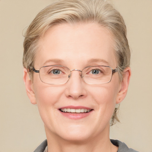 Joyful white middle-aged female with medium  blond hair and blue eyes