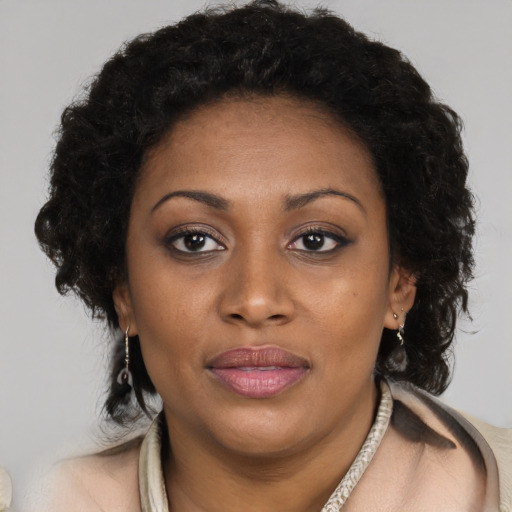 Joyful black adult female with long  brown hair and brown eyes