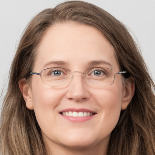 Joyful white adult female with long  brown hair and grey eyes