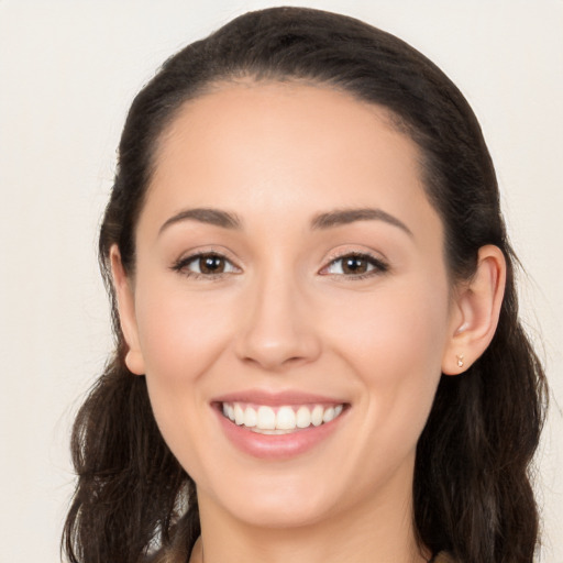 Joyful white young-adult female with long  brown hair and brown eyes