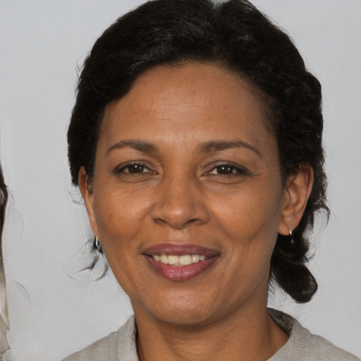 Joyful black adult female with medium  brown hair and brown eyes