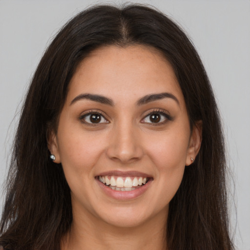 Joyful white young-adult female with long  brown hair and brown eyes