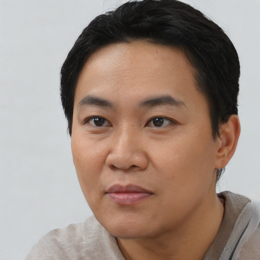 Joyful asian young-adult male with short  black hair and brown eyes