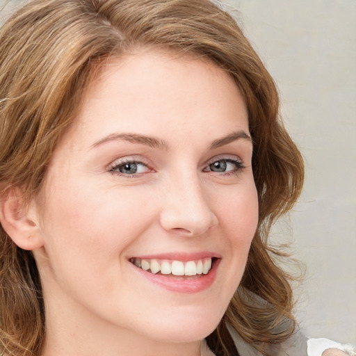 Joyful white young-adult female with long  brown hair and blue eyes