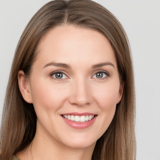 Joyful white young-adult female with long  brown hair and grey eyes