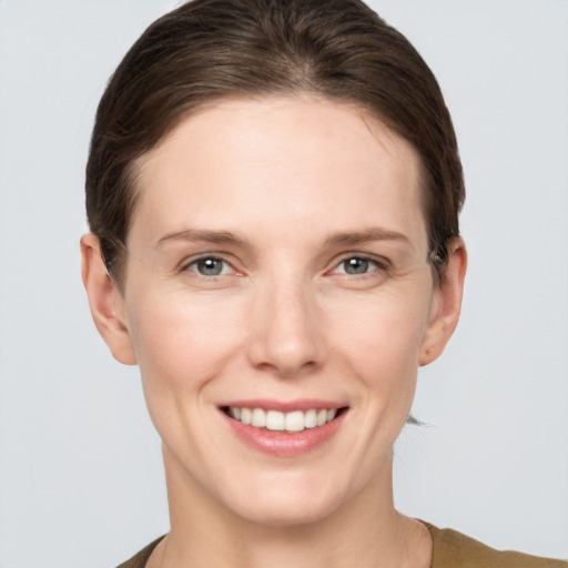 Joyful white young-adult female with short  brown hair and grey eyes