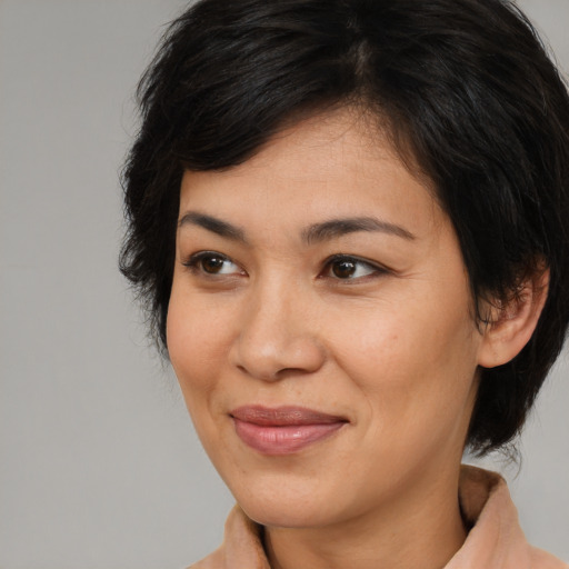 Joyful asian adult female with medium  brown hair and brown eyes
