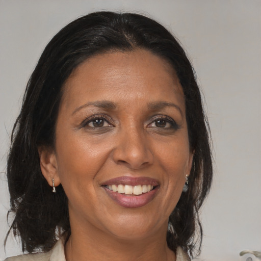 Joyful black adult female with medium  brown hair and brown eyes