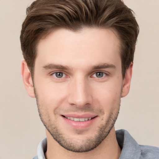 Joyful white young-adult male with short  brown hair and grey eyes