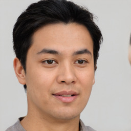 Joyful asian young-adult male with short  brown hair and brown eyes