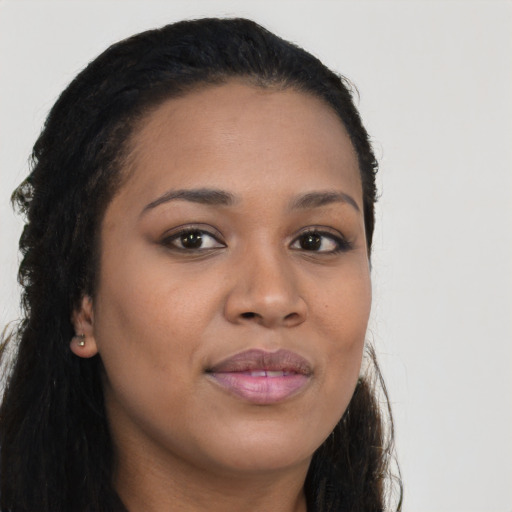 Joyful black young-adult female with long  brown hair and brown eyes
