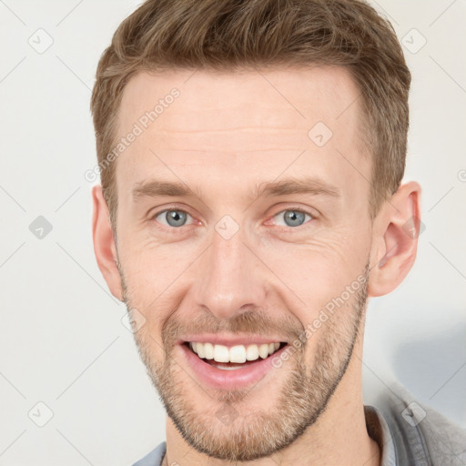 Joyful white young-adult male with short  brown hair and grey eyes