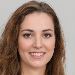 Joyful white young-adult female with long  brown hair and green eyes