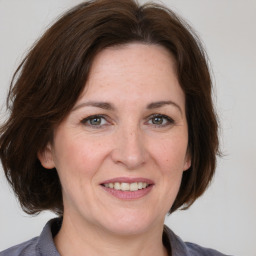 Joyful white adult female with medium  brown hair and grey eyes