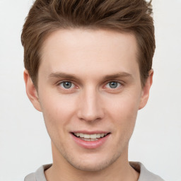 Joyful white young-adult male with short  brown hair and grey eyes