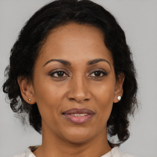 Joyful black adult female with medium  brown hair and brown eyes