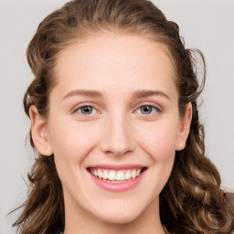 Joyful white young-adult female with long  brown hair and blue eyes