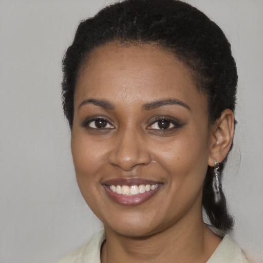 Joyful black young-adult female with medium  brown hair and brown eyes