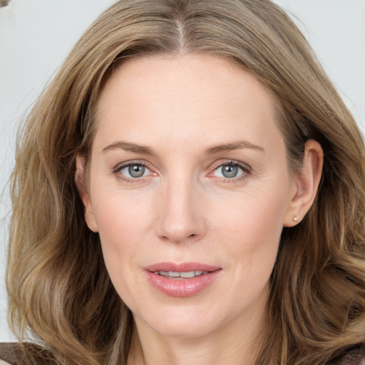 Joyful white young-adult female with long  brown hair and blue eyes