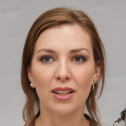 Joyful white young-adult female with medium  brown hair and grey eyes