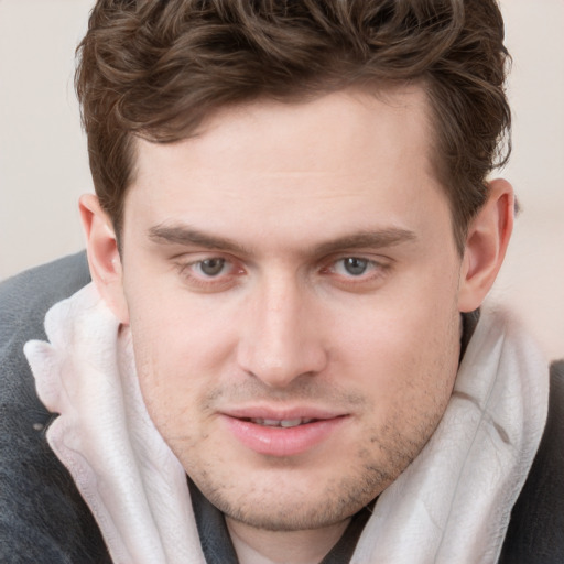 Joyful white young-adult male with short  brown hair and blue eyes