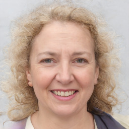 Joyful white adult female with medium  brown hair and blue eyes