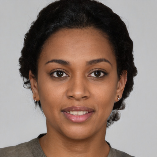 Joyful black young-adult female with short  brown hair and brown eyes