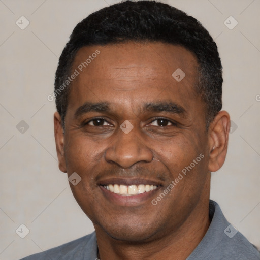 Joyful black adult male with short  black hair and brown eyes