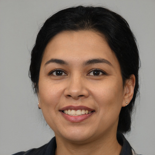 Joyful latino young-adult female with medium  black hair and brown eyes