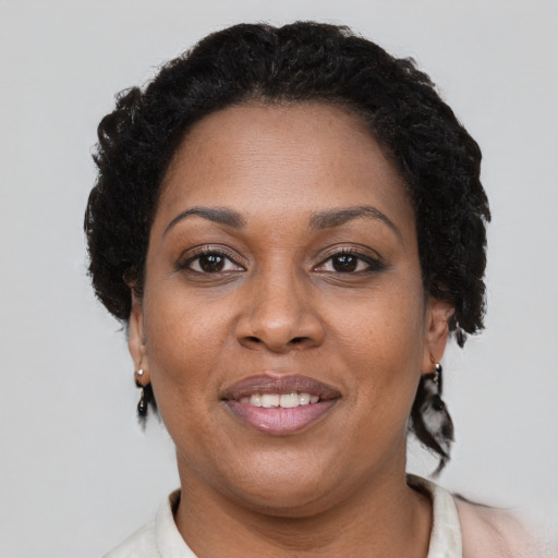 Joyful black adult female with short  brown hair and brown eyes