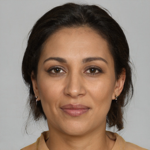 Joyful latino young-adult female with medium  brown hair and brown eyes