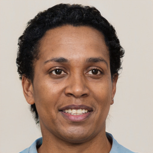 Joyful black adult female with short  black hair and brown eyes