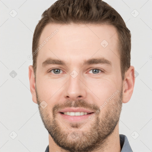 Joyful white young-adult male with short  brown hair and grey eyes