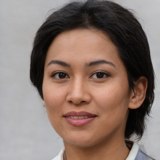 Joyful asian young-adult female with medium  brown hair and brown eyes