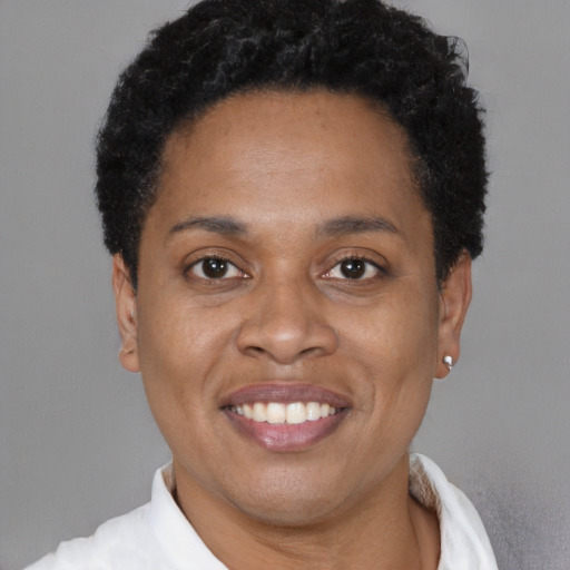 Joyful black adult female with short  black hair and brown eyes