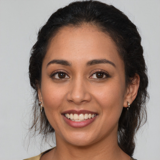 Joyful latino young-adult female with medium  brown hair and brown eyes