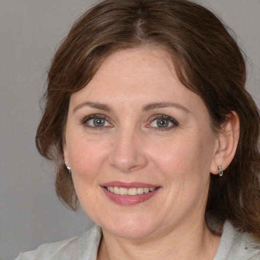 Joyful white adult female with medium  brown hair and grey eyes