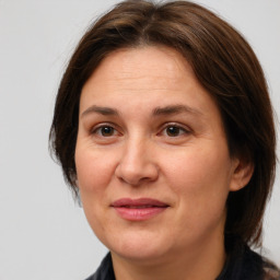 Joyful white adult female with medium  brown hair and brown eyes