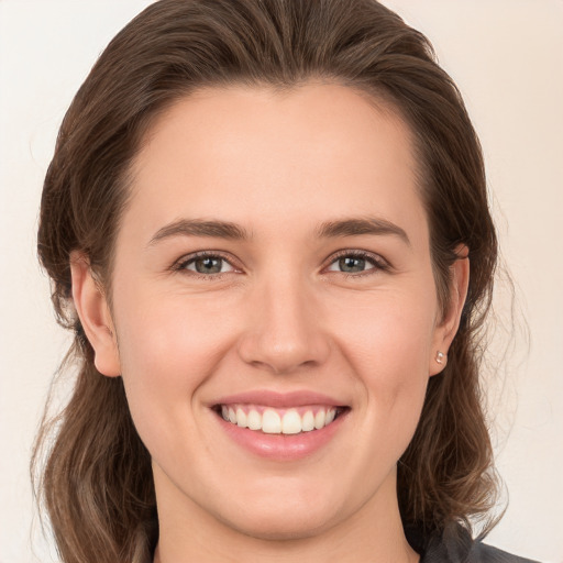 Joyful white young-adult female with medium  brown hair and grey eyes