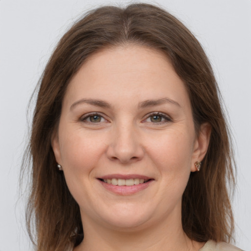 Joyful white adult female with long  brown hair and grey eyes