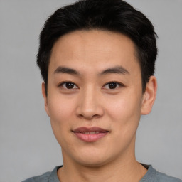 Joyful asian young-adult male with short  black hair and brown eyes