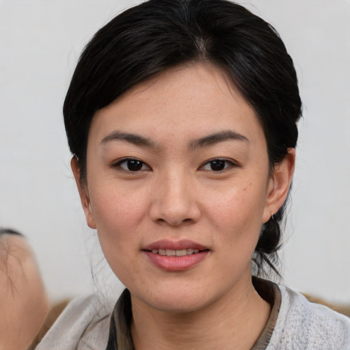 Joyful asian young-adult female with medium  black hair and brown eyes