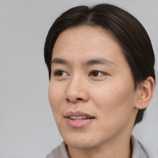 Joyful asian young-adult male with medium  brown hair and brown eyes