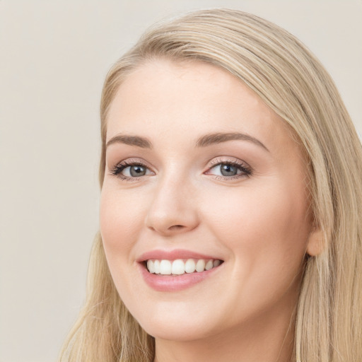 Joyful white young-adult female with long  brown hair and blue eyes