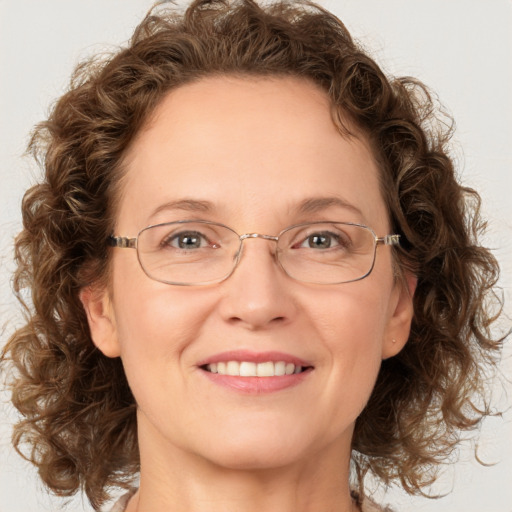 Joyful white adult female with medium  brown hair and green eyes