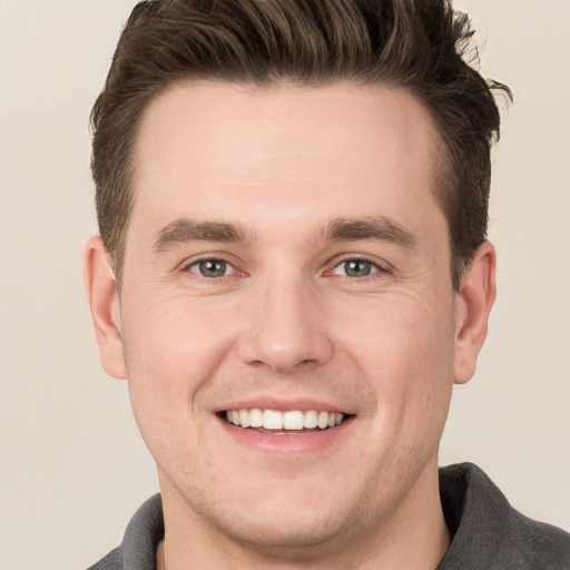 Joyful white young-adult male with short  brown hair and grey eyes