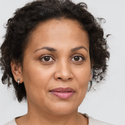 Joyful latino adult female with short  brown hair and brown eyes