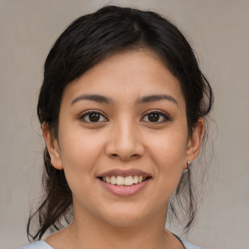 Joyful latino young-adult female with medium  brown hair and brown eyes